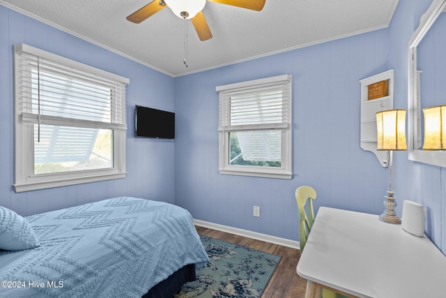 bedroom with wood walls, crown molding, dark hardwood / wood-style floors, ceiling fan, and a textured ceiling