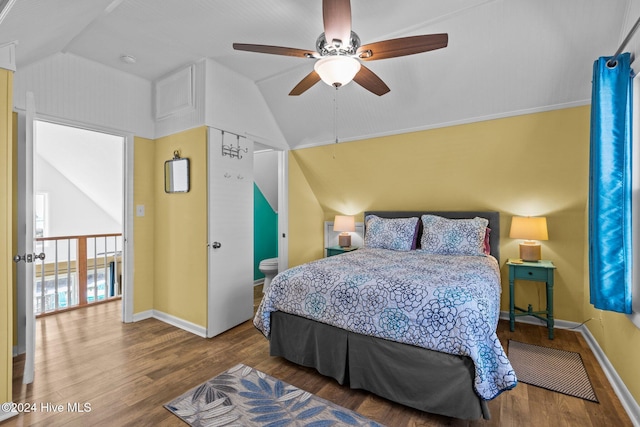 bedroom featuring hardwood / wood-style flooring, ensuite bath, ceiling fan, and lofted ceiling