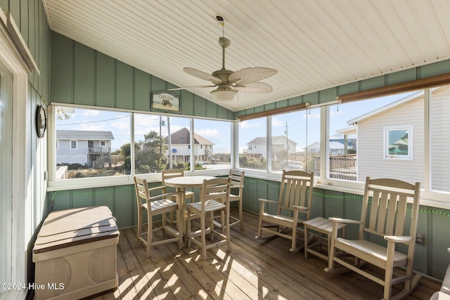 sunroom with ceiling fan and vaulted ceiling