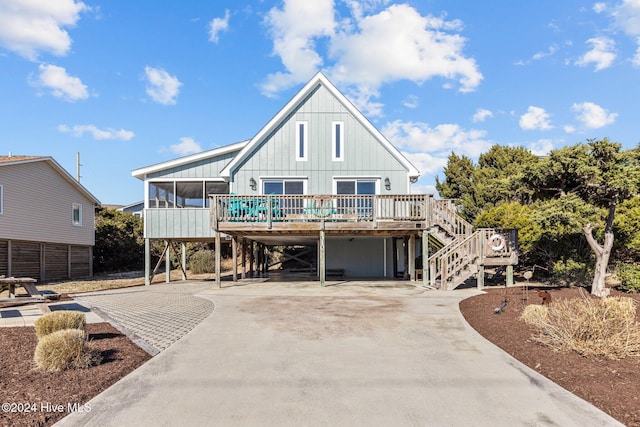 view of front of house featuring a carport, a sunroom, and a deck