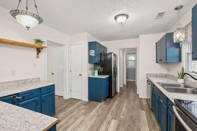 kitchen featuring refrigerator with ice dispenser, blue cabinets, and light wood-style floors