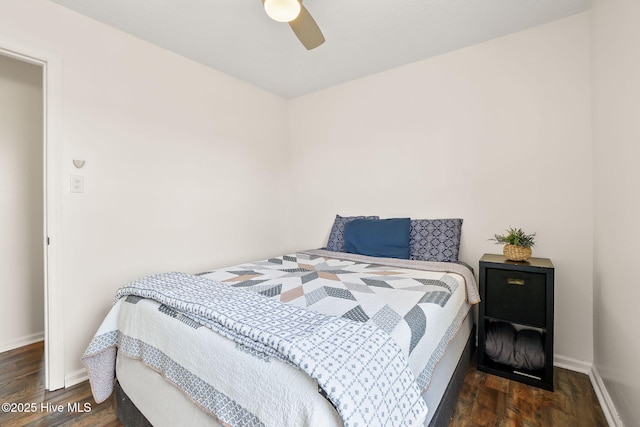 bedroom featuring baseboards, wood finished floors, and a ceiling fan