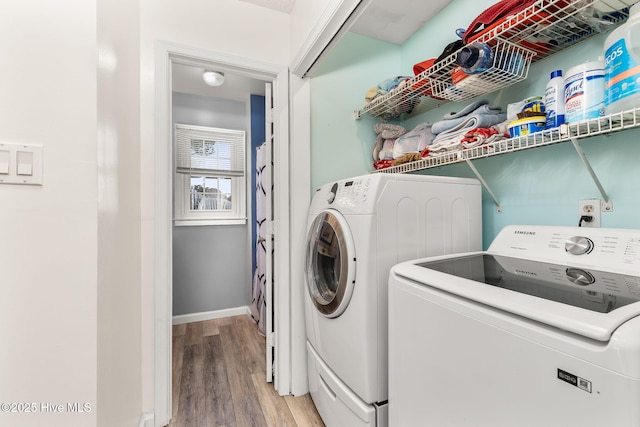 washroom featuring baseboards, separate washer and dryer, laundry area, and light wood finished floors