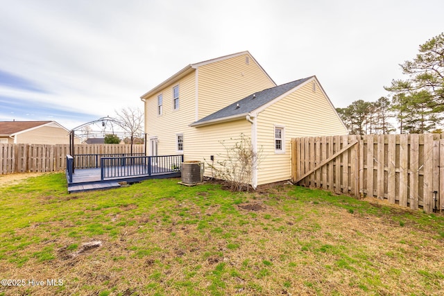 back of house with a yard, a wooden deck, central AC unit, and a fenced backyard