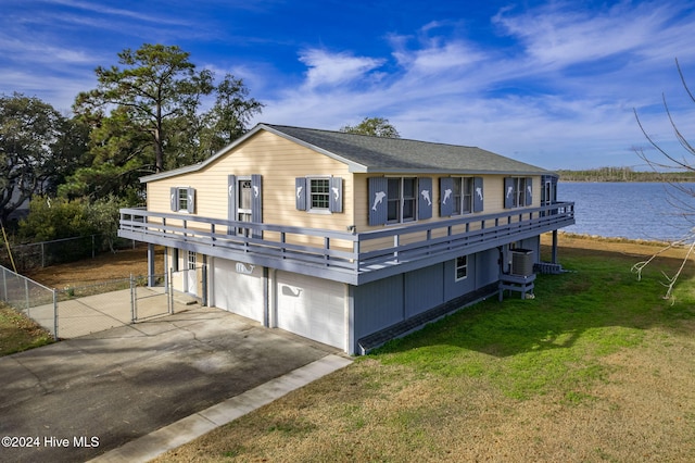 view of front of house featuring driveway, a water view, a gate, central AC, and a front yard