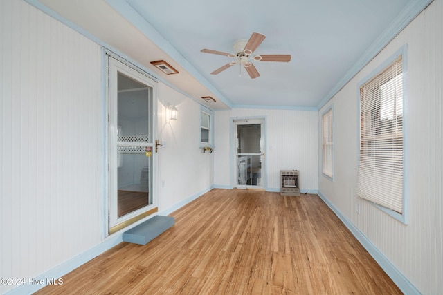 spare room with heating unit, visible vents, light wood-style flooring, ceiling fan, and baseboards