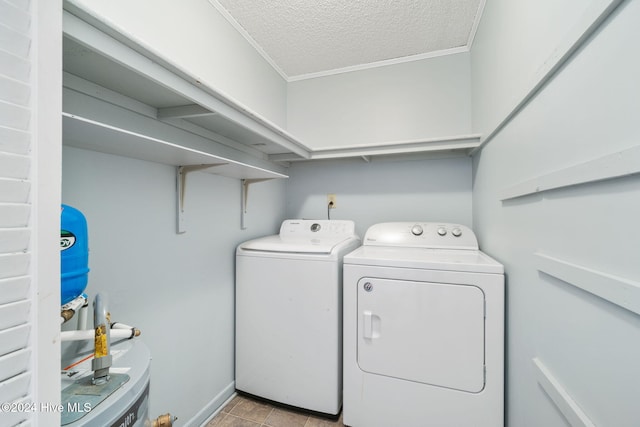 laundry room featuring laundry area, ornamental molding, washer and clothes dryer, and a textured ceiling