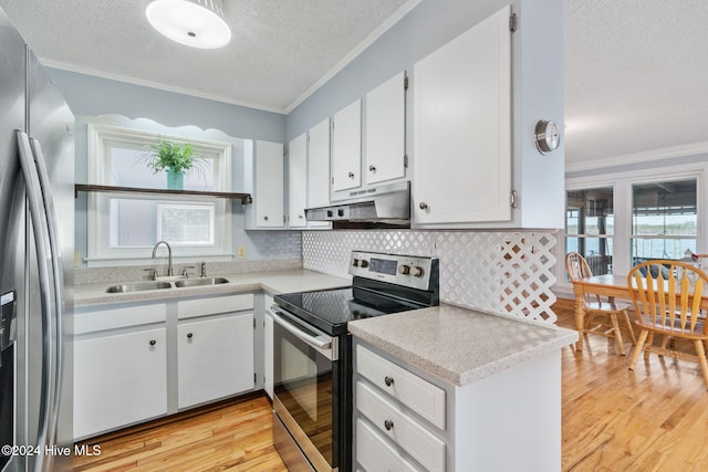 kitchen with appliances with stainless steel finishes, light countertops, crown molding, under cabinet range hood, and a sink