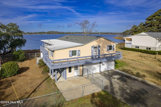 view of front of property featuring a garage, a water view, fence, and driveway