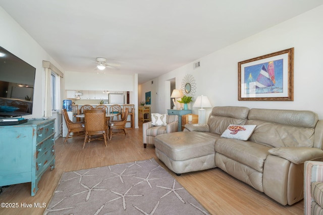 living room featuring light hardwood / wood-style floors and ceiling fan