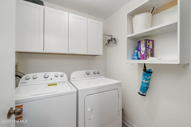 clothes washing area featuring washer and clothes dryer and cabinets