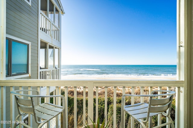 balcony with a water view and a beach view