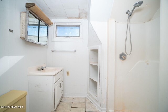 bathroom featuring tile patterned flooring, vanity, and walk in shower