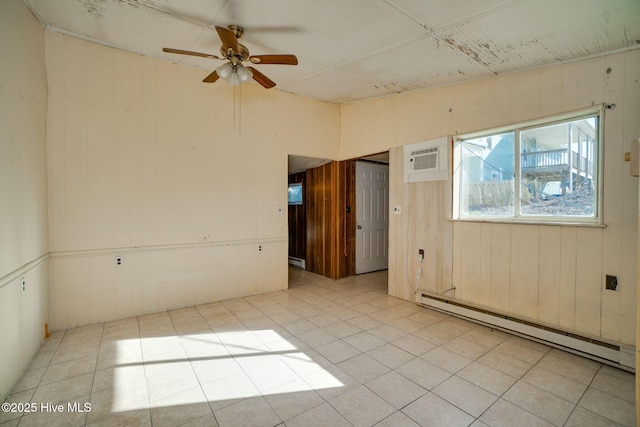 unfurnished room with a wall mounted air conditioner, ceiling fan, wood walls, and a baseboard radiator