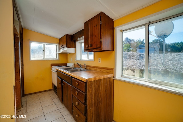 kitchen featuring vaulted ceiling, light tile patterned flooring, sink, and white stove