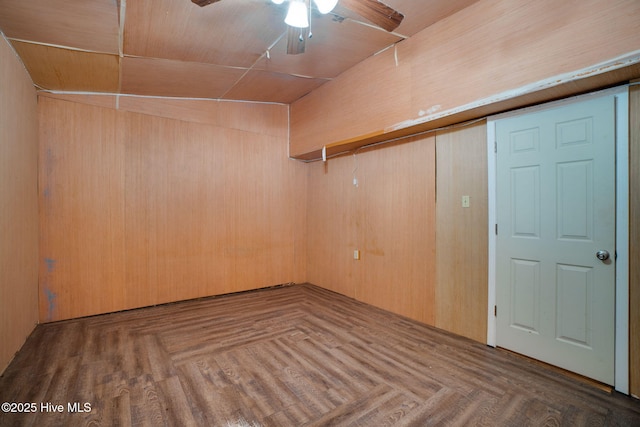 spare room with ceiling fan, lofted ceiling, and wooden walls