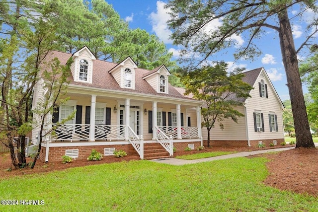 cape cod house with covered porch and a front lawn