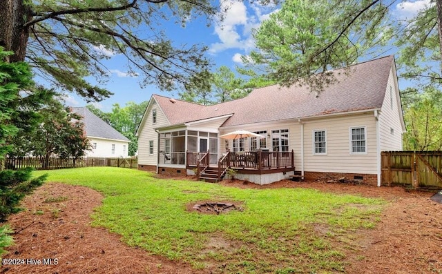 rear view of house featuring a sunroom, a yard, and a deck