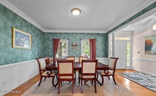 dining room featuring ornate columns, crown molding, and light hardwood / wood-style floors