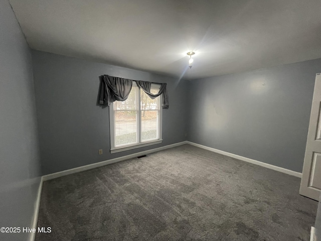 empty room with dark colored carpet