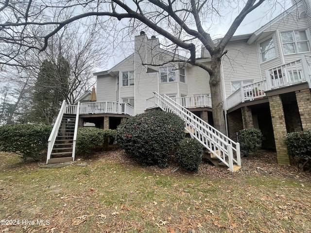 view of side of home featuring a deck and a lawn