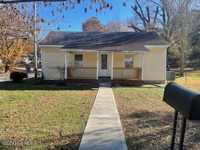 bungalow-style home with central AC, a porch, and a front yard