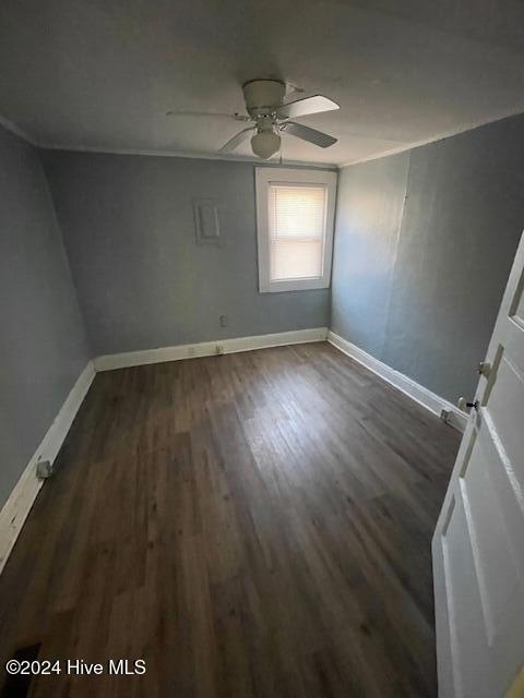 empty room with ceiling fan and dark hardwood / wood-style flooring