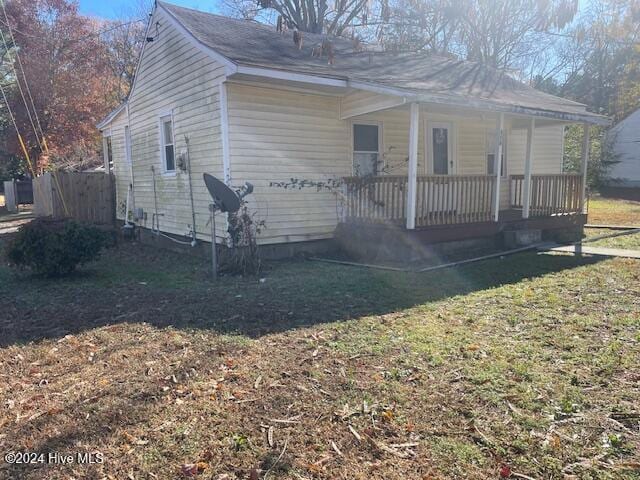 view of property exterior with a porch and a lawn