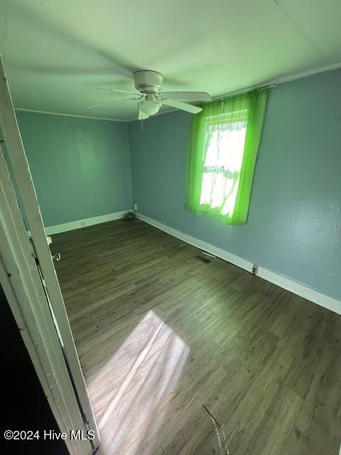 unfurnished room featuring ceiling fan and dark wood-type flooring