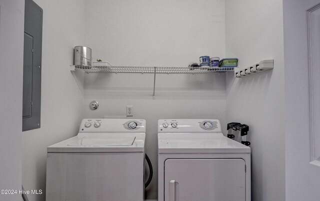 washroom featuring electric panel and washer and clothes dryer