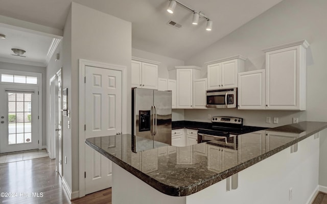 kitchen featuring lofted ceiling, dark wood-type flooring, white cabinets, kitchen peninsula, and stainless steel appliances