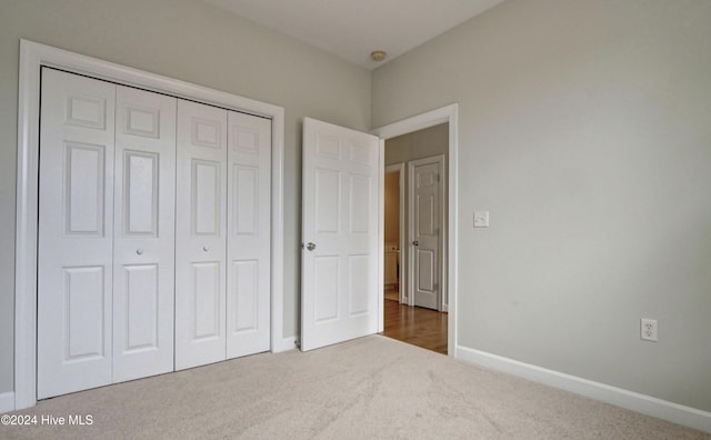 unfurnished bedroom featuring carpet flooring and a closet