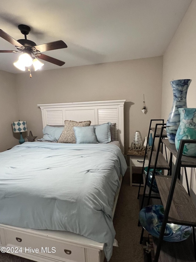 bedroom featuring ceiling fan and dark carpet