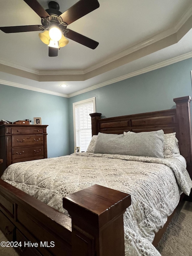 bedroom featuring a tray ceiling, ceiling fan, and ornamental molding