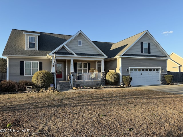 craftsman inspired home featuring covered porch, a garage, and a front yard