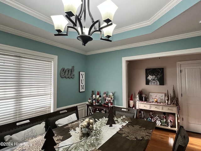 dining space featuring wood-type flooring, ornamental molding, and a notable chandelier