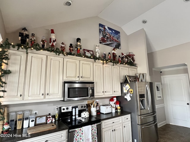 kitchen with appliances with stainless steel finishes and lofted ceiling