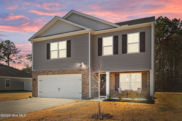 craftsman-style house featuring a garage and a yard