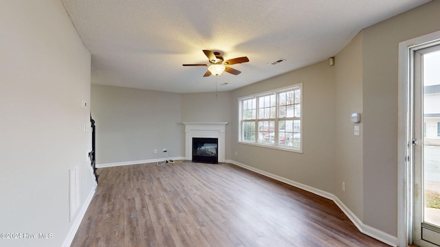 unfurnished living room featuring a textured ceiling, hardwood / wood-style flooring, and ceiling fan