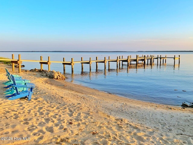 view of dock with a water view and a view of the beach