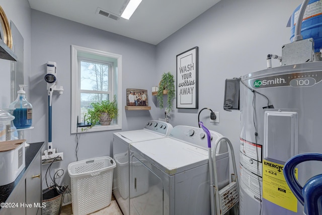 washroom with washing machine and clothes dryer and electric water heater