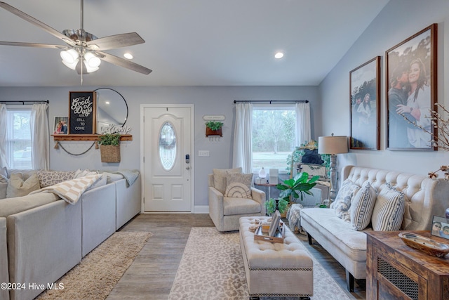 living room featuring light hardwood / wood-style floors, ceiling fan, and lofted ceiling