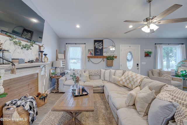 living room with light hardwood / wood-style flooring, plenty of natural light, lofted ceiling, and ceiling fan