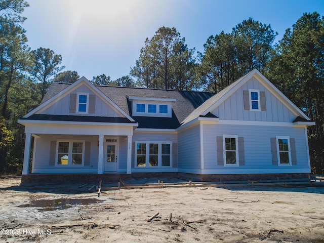 view of front facade featuring board and batten siding and a shingled roof