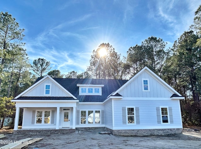 back of property featuring board and batten siding and roof with shingles