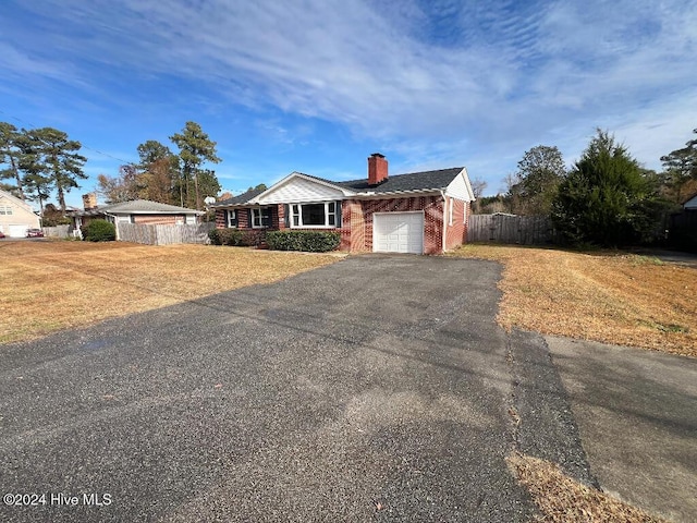 single story home featuring a front lawn and a garage