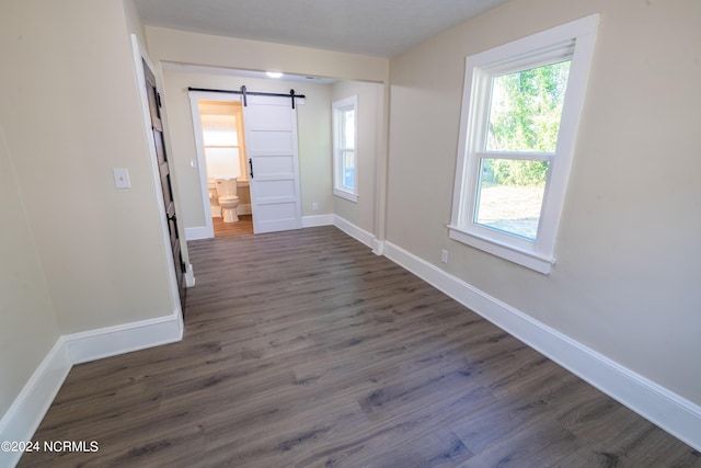 interior space featuring a barn door and dark hardwood / wood-style floors