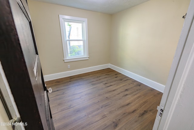 unfurnished room with wood-type flooring