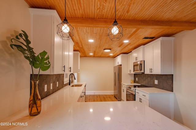 kitchen with decorative light fixtures, appliances with stainless steel finishes, backsplash, and sink