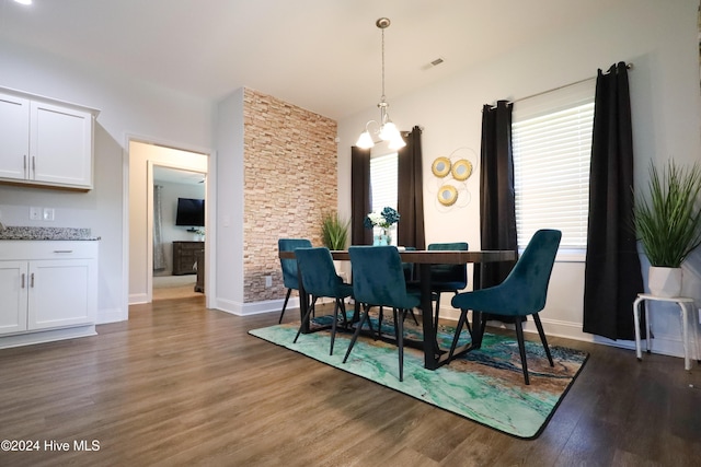 dining space featuring plenty of natural light, dark hardwood / wood-style floors, and an inviting chandelier